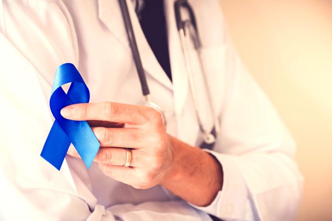 Médecin tenant le ruban bleu symbole du dépistage du cancer colorectal