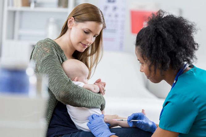 Un nouveau né reçoit un vaccin dans les bras de sa maman
